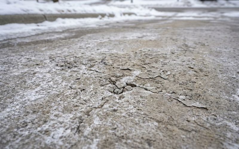 Salt damage effects on concrete driveway surface in Buffalo NY